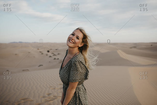 Portrait of happy blond woman standing on sand dune- Algodones Dunes- Brawley- USA