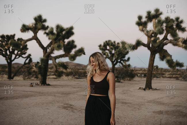 Smiling blond woman walking in the desert at dusk- Joshua Tree- USA Joshua Tree- USA