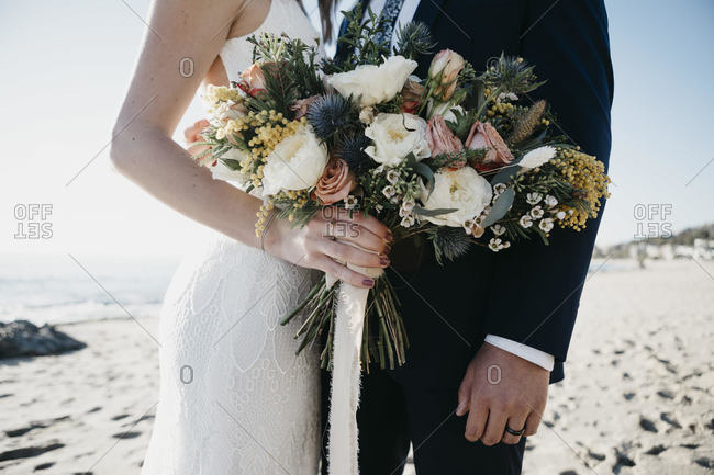 Bridal couple with bridal bouquet at the beach