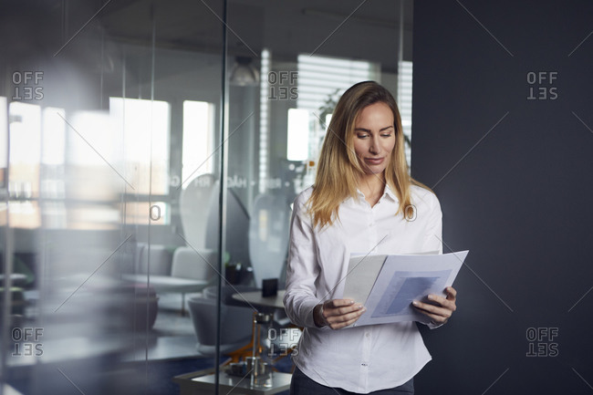 Portrait of businesswoman reviewing papers in office