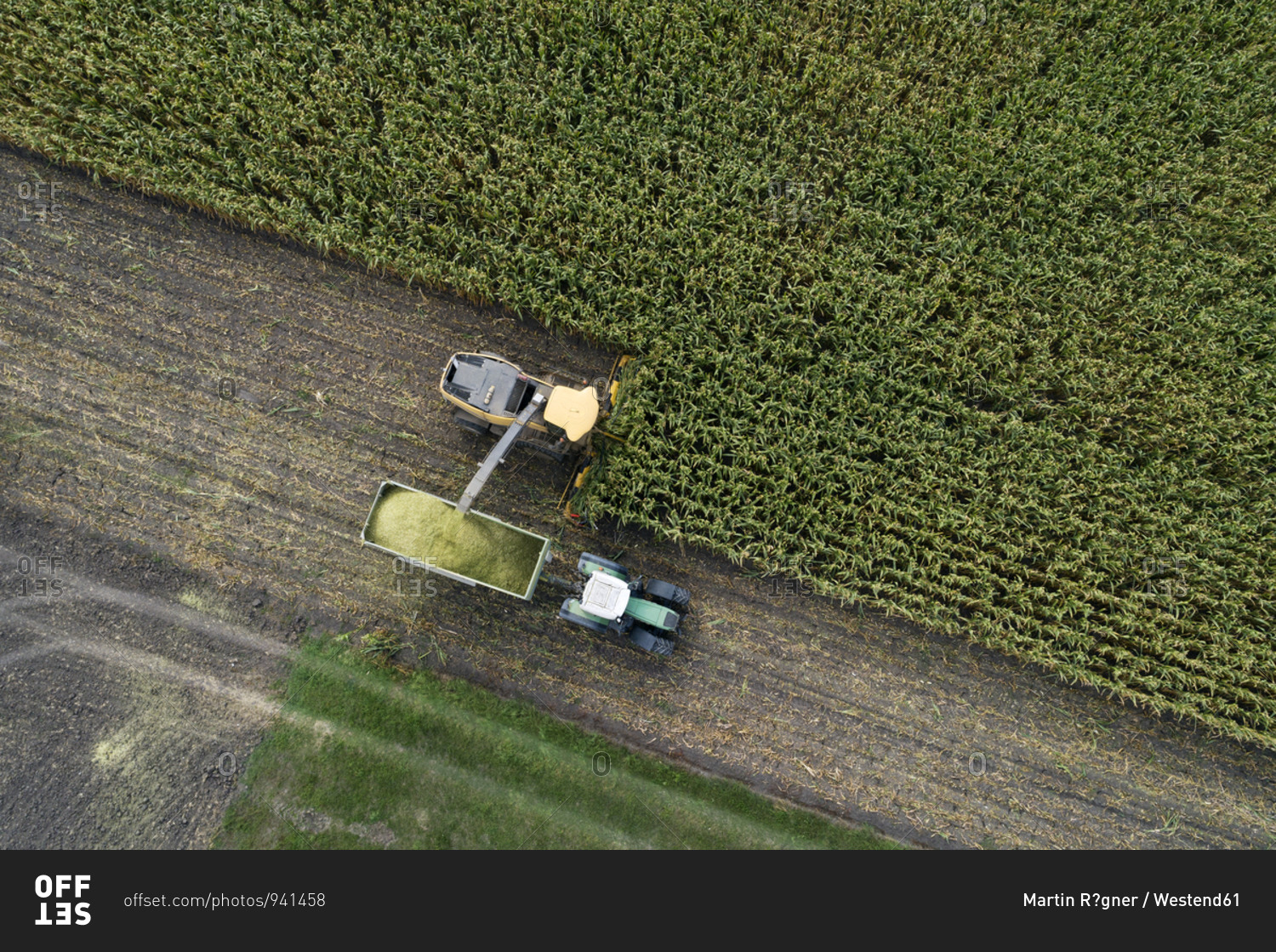 Germany- Bavaria- Drone view of combine and tractor harvesting corn