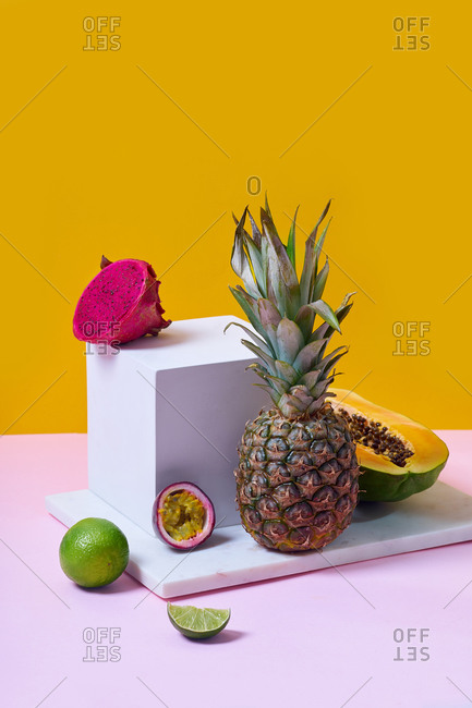 Still life with summer fruits and white cube on colorful background