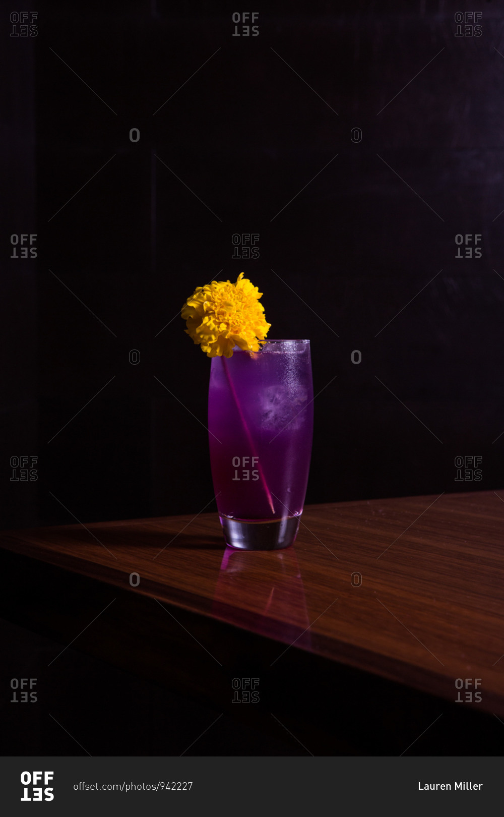 Purple cocktail with a large yellow flower