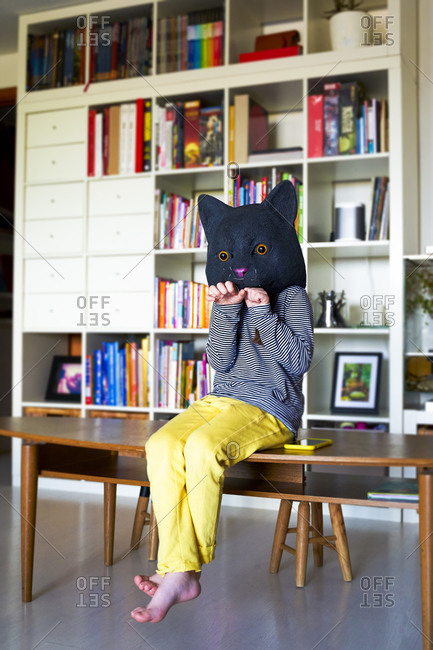 Little girl sitting at home- imitating cat- wearing mask