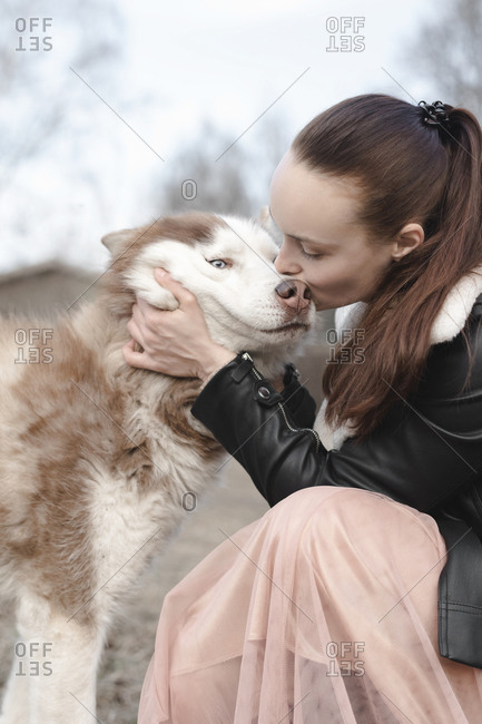 Woman kissing her husky dog
