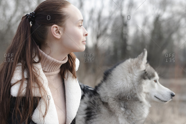 Woman and her husky looking at distance