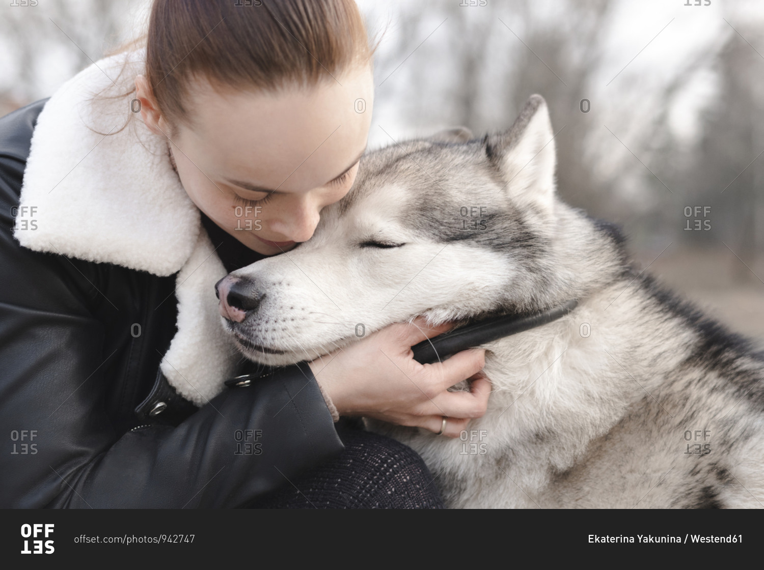 Woman cuddling her husky dog