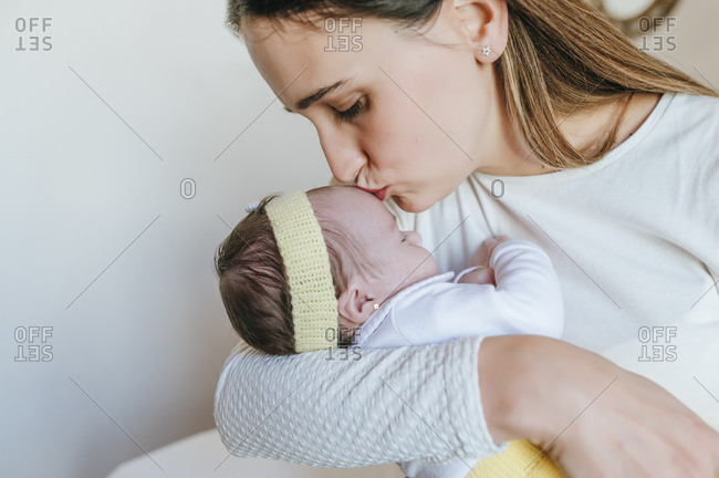Close-up of mother kissing her daughter indoors