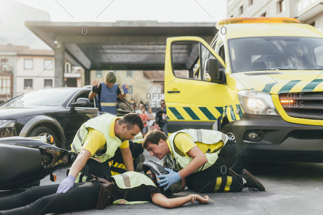 Paramedics helping crash victim after scooter accident