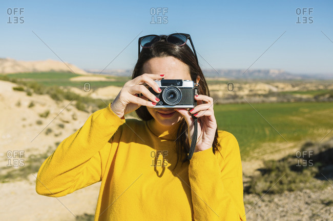 Woman taking pictures with a vintage camera- Bardenas Reales- Arguedas- Navarra- Spain