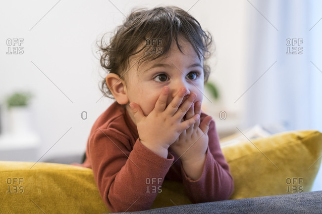 A two year old toddler drinking a bottle of baby milk, while sitting,  lying, on a settee playing on her iPad Stock Photo - Alamy