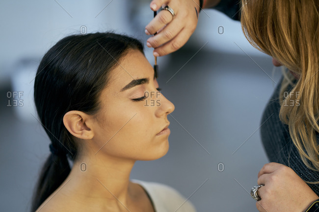 Close-up of a make-up artist touching up a model's face