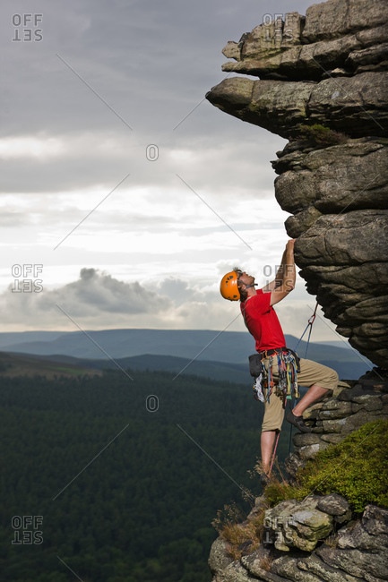 Rock climber on cliff at the Peak District in England