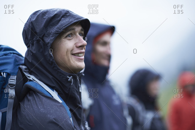 Young male hiker with friends in hooded anoraks in rain, Manigod, Rhone-Alpes, France