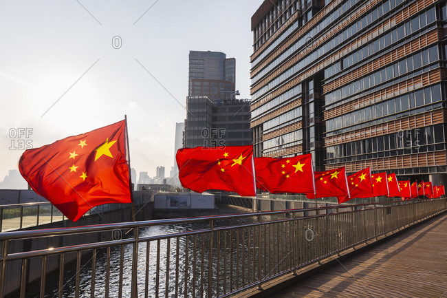 January 30, 2019: Row of Chinese flags on Huangpu river promenade, Shanghai, China