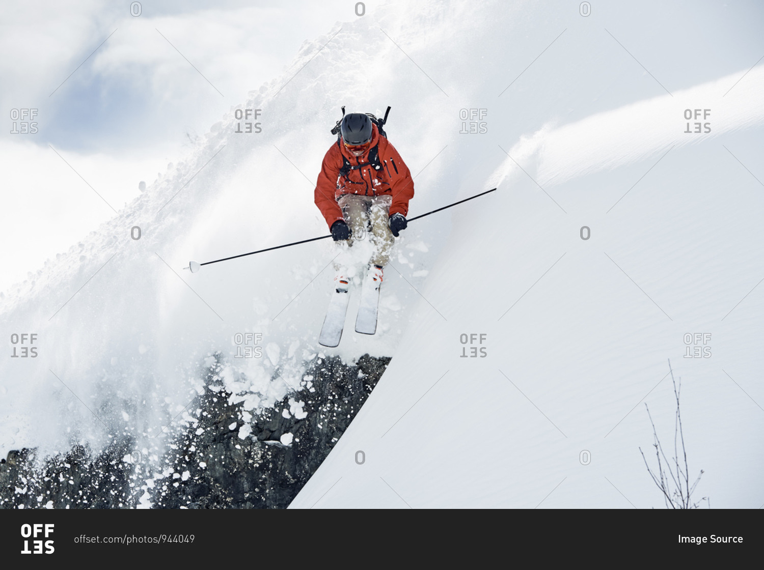 Male skier skiing mid air down snow covered mountain, Alpe-d'Huez, Rhone-Alpes, France