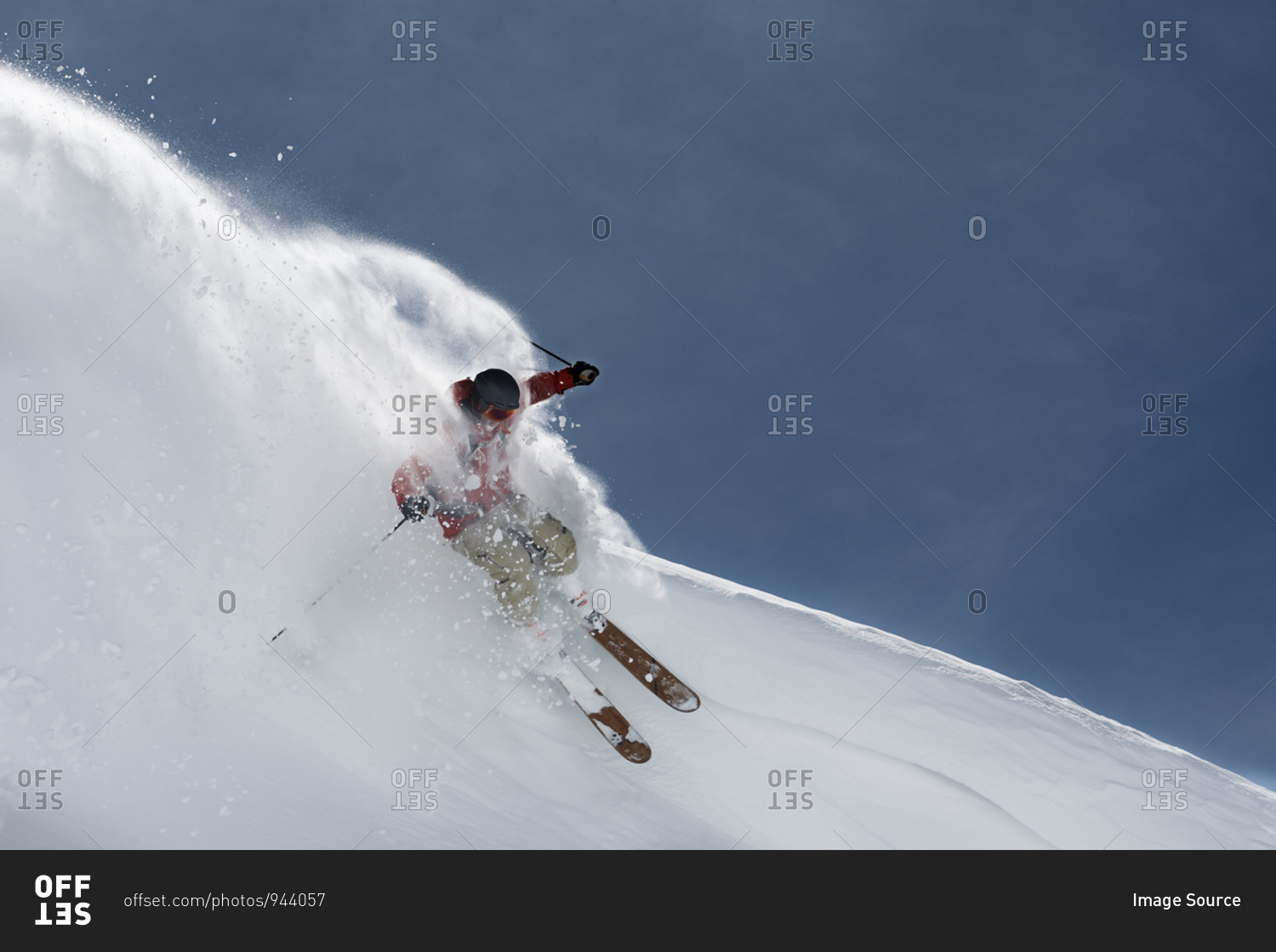 Male skier skiing down steep mountainside, Alpe-d'Huez, Rhone-Alpes, France