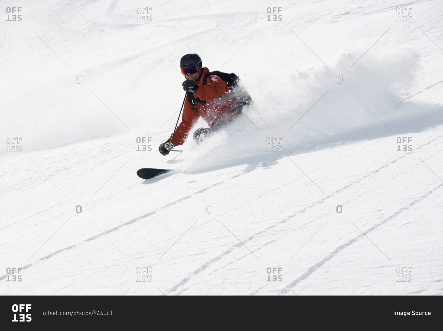 Male skier skiing down mountain, Alpe-d'Huez, Rhone-Alpes, France