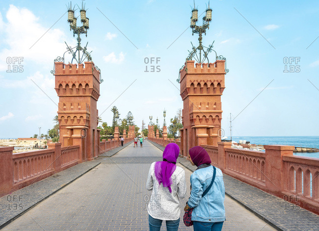 Two female tourists taking photograph on Montaza palace bridge, Alexandria, Egypt