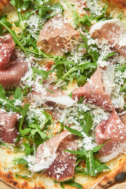 Close up of pizza with arugula and prosciutto