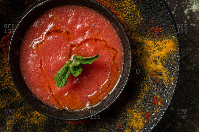 Healthy Homemade Tomato Soup with Bread, Mint and Olive Oil on Dark Background from above. Vegan food concept