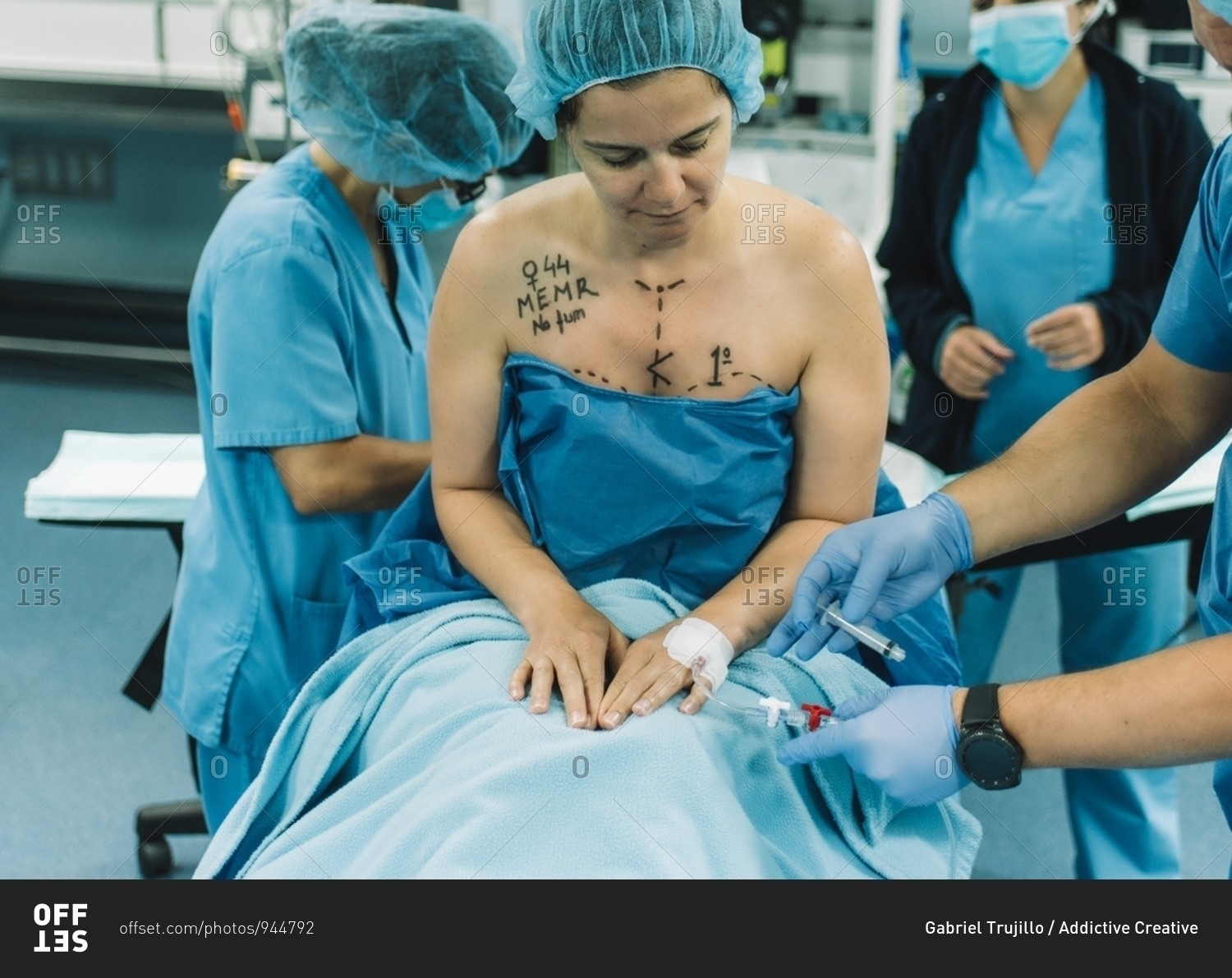 Blurred surgeon using photo camera to shoot breast of female