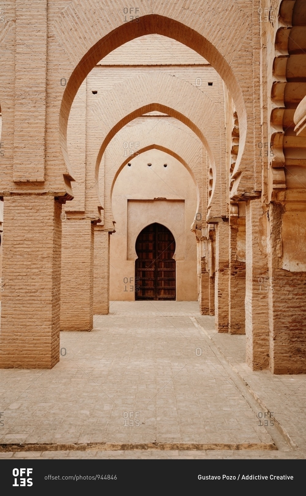 Aged stone building with columns and ornamental carved arches in old city Marrakesh in Morocco