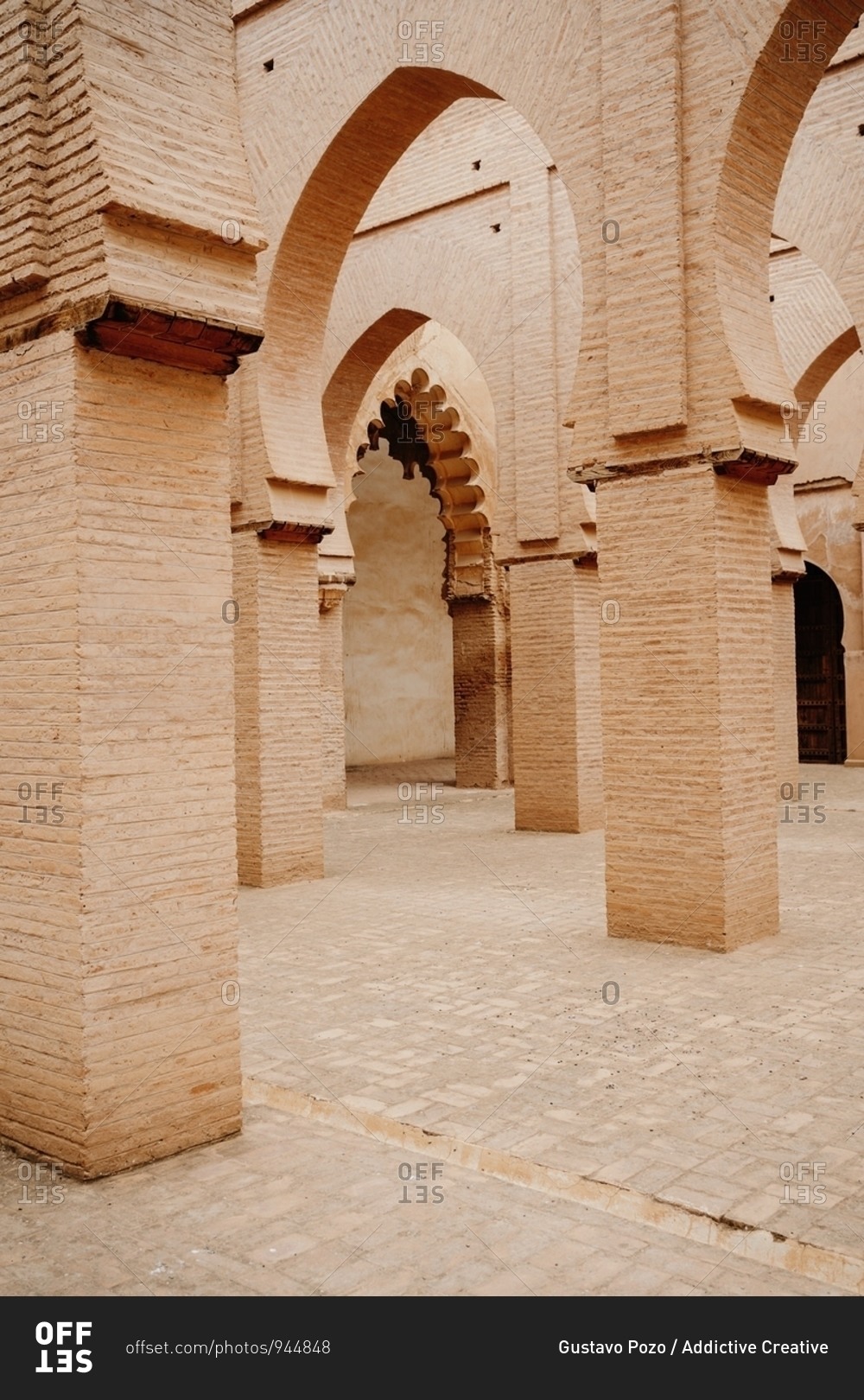 Aged stone building with columns and ornamental carved arches in old city Marrakesh in Morocco