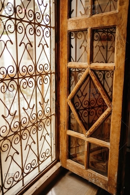Old vintage window with wooden frames and ornamental grid in ancient house in Marrakesh city
