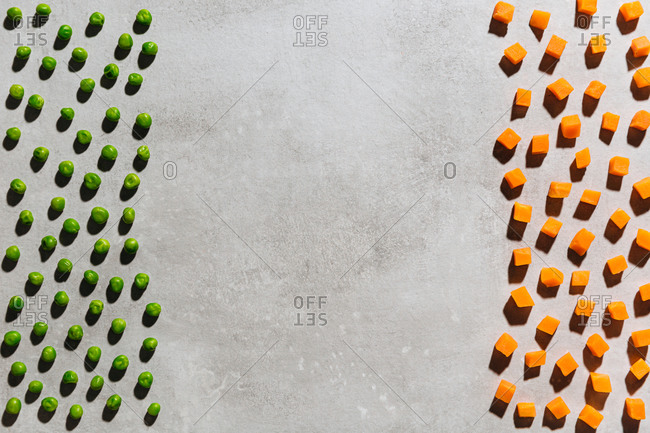 Diced frozen peas and carrots on gray background