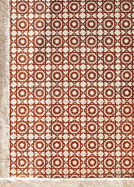 Red decorative tile on home exterior in Lisbon, Portugal