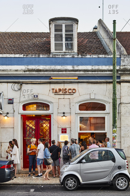 Lisbon, Portugal - July 19, 2019: Patrons outside of a restaurant at sunset