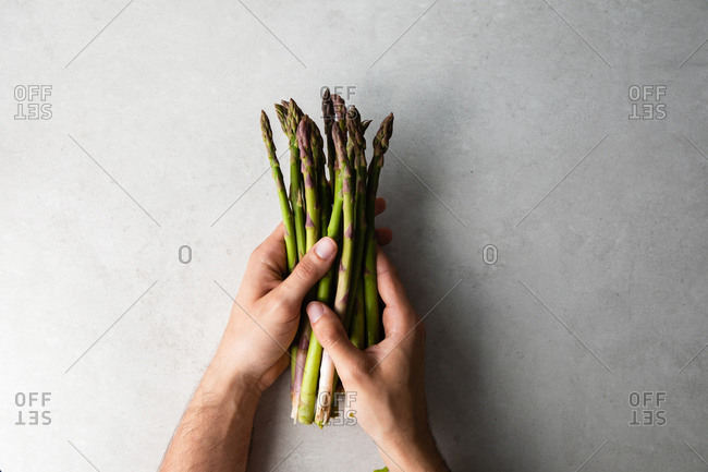 Cook holding bunch of fresh asparagus