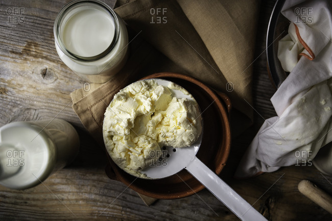 Homemade mascarpone cheese with a slotted spoon on a vintage atmosphere