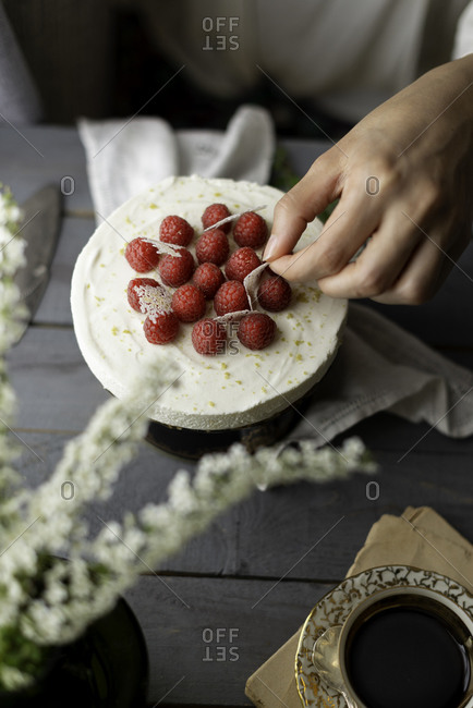 Uncooked creamy cheesecake decorated with fresh raspberries ready to get shared