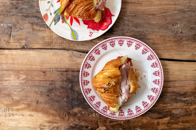 Ham and cheese croissant sandwich on rustic wooden table