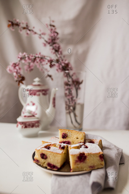 Cherry cake slices on a plate with tea and cherry blossoms