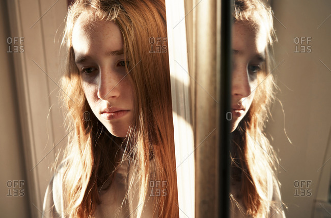 depressed girl looking in mirror