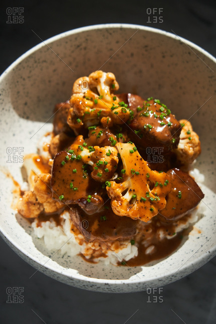 Overhead view of an Asian beef dish with cauliflower and chives