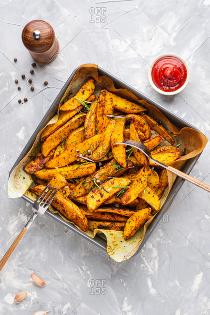 Baked potato wedges with sea salt, ketchup and rosemary