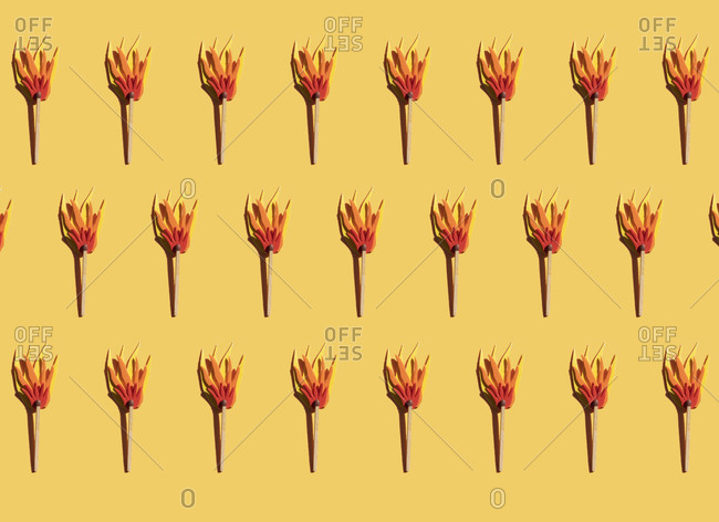 Pattern of matches with cardboard flame against yellow background