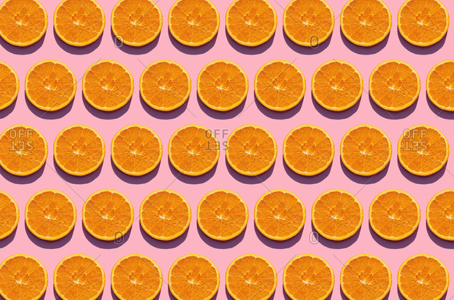 Pattern of orange slices against pink background