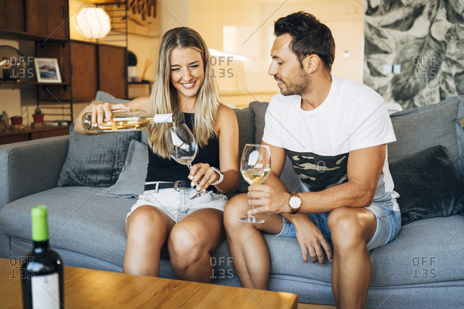 Couple sitting on the couch with glasses of white wine