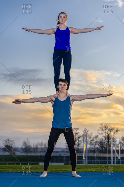 Young Couple Doing Acroyoga, Yoga with Partner, Double Downward