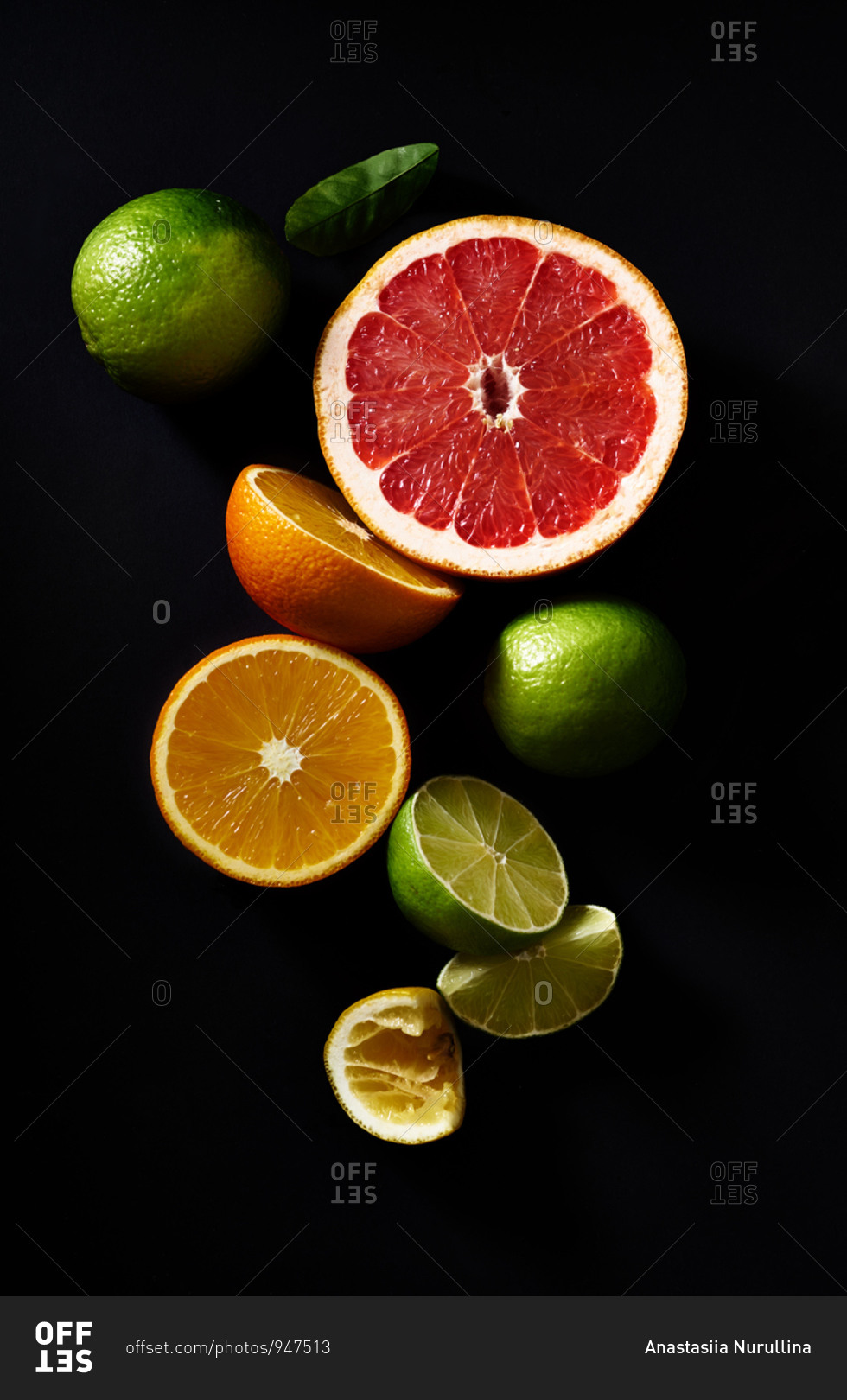 Sliced citrus fruits on black background: grapefruit, lime, orange, lemon