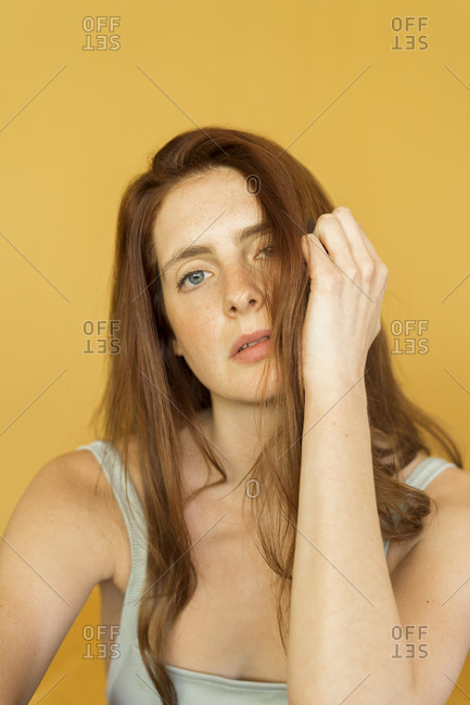 Portrait of redheaded woman against yellow background