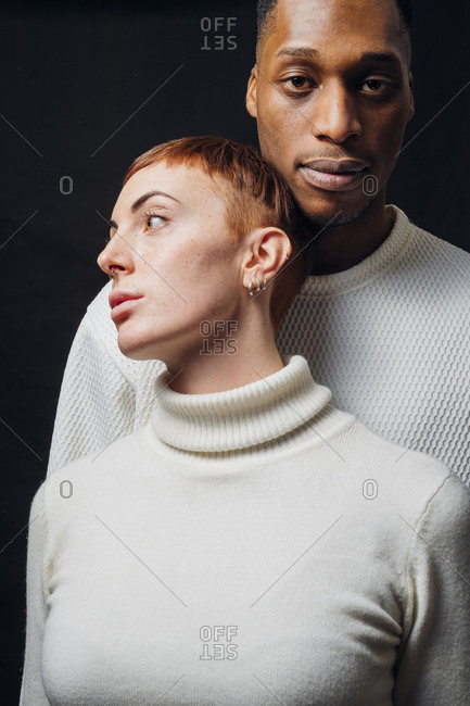 Studio portrait of mixed race couple wearing white sweaters