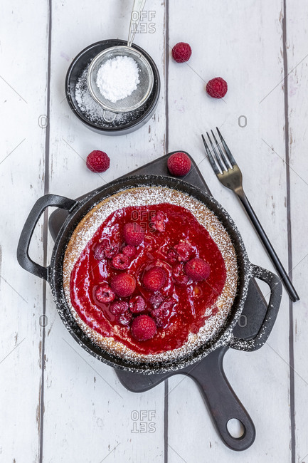 Dutch baby pancake with raspberries- raspberry coulis and powdered sugar