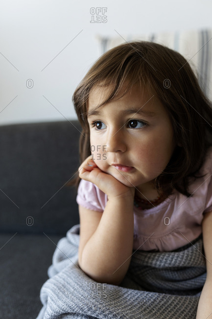 Portrait of girl sitting on couch at home
