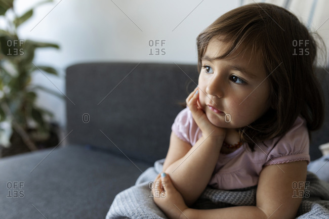 Portrait of girl sitting on couch at home